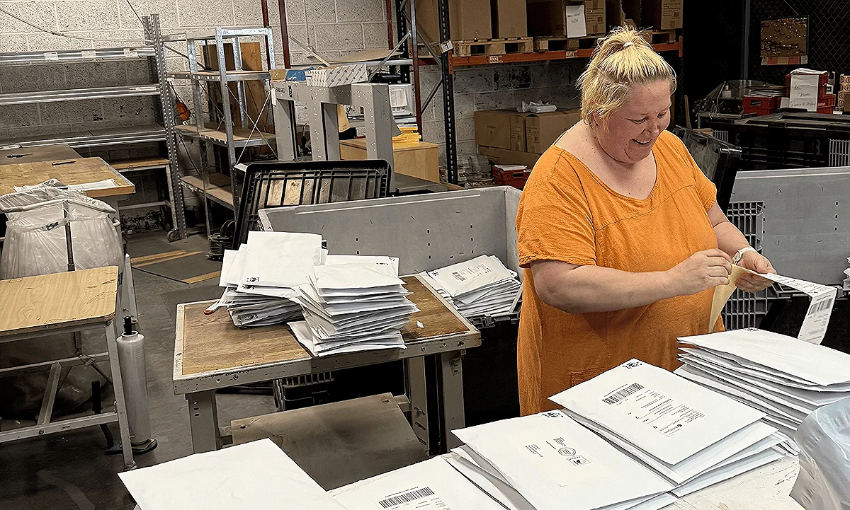 Manuell pakking utført av smilende kvinnelig kollega i Aksell logistikk