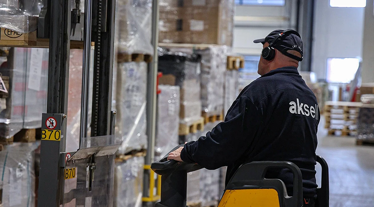 Mann losser varer med gaffeltruck hos Aksell Logistikk